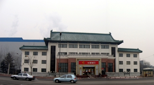 Pagoda-influenced building with two cars out front.