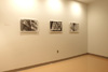 Three black and white photos displayed in an otherwise empty room.