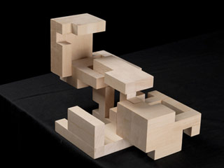 A wooden cube with separating parts in an open position.