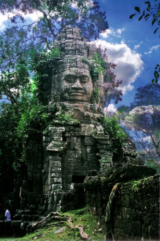 Photograph of a tower with carved face, part of the Angkor city gates.