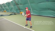 The player holds the racket in the forehand grip, with the head aligned straight up and down, tilted forward toward the net, and the left hand lightly steadying it at the neck.