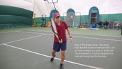 Stepping across with the left foot, the racket swings forward, making contact with the ball before it passes.