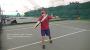 The left hand lets go as the racket swings forward, still tilted up, and the player steps across with the right foot.
