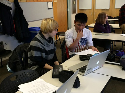 Two students working together on a computer.