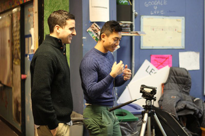 Two students working together with a tripod and camera