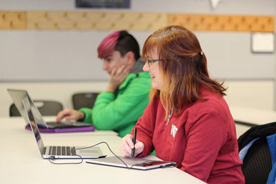 Two students working on computers creating an animation.