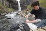 Sampling water in front of a waterfall.
