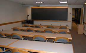 A photograph of a small classroom with a small chalkboard at the front of the room.