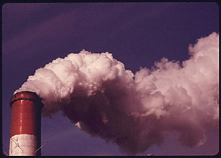A photograph of smoke billowing out of a stack at a power station.