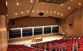 Lecture hall with red tiered tablet chairs.