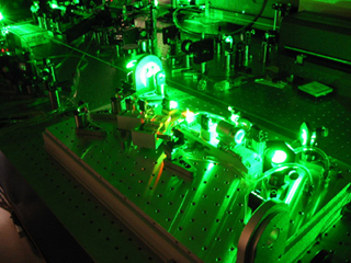A photograph of a laser emitting a green light.