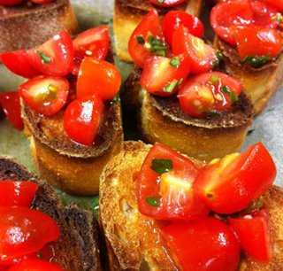 Bright red tomatoes lay on top of toasted bread.