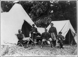 A photograph of civil war soldiers sitting in a camp.