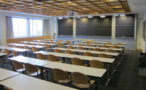 A lecture-style classroom with desks and chalkboards.