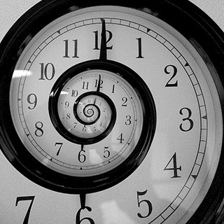 A black and white clock with a swirling face to indicate time travel.