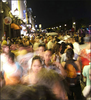 A crowd of people on the street at night.