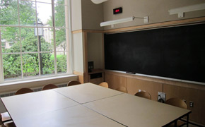 This photo shows how chairs in the classroom surround a central table so students all face each other in a seminar-style classroom.