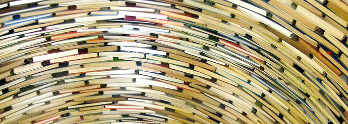 A photograph of stacked books arranged as a statue.