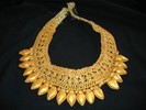 Large leaf-shaped gold beads alternate with small gold pony beads, attached to a wide gold trim band.