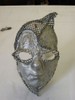 The eyeholes on this mask are shaped around cat-eye glasses, and the mesh section points aggressively at the top left before curving down to the left eyebrow and around the right side.