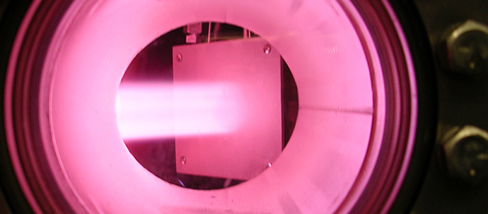 A strong pink glow seen through a reinforced porthole.