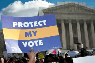 A hand holds a poster with the words "Protect My Vote" in front of the U.S. Supreme Court building.