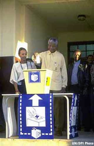Photograph of Nelson Mandela about to place his ballot in a box during 1994 elections.