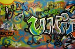 A multicolored street art mural with various images and text.