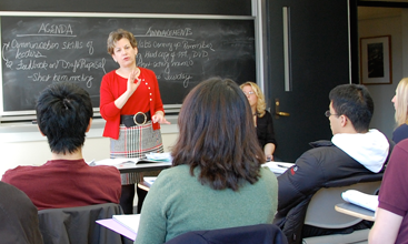 A photo of Dr. Breslow with a room of seated students in front of her, and blackboards behind her.